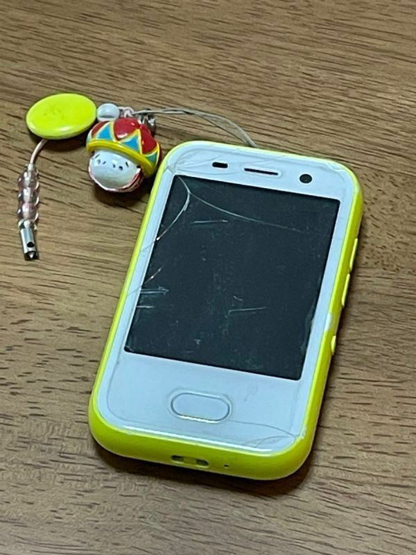 耀子さんが持っていたキッズ携帯。ストラップにはパパからもらった沖縄土産がつけられている（筆者撮影）