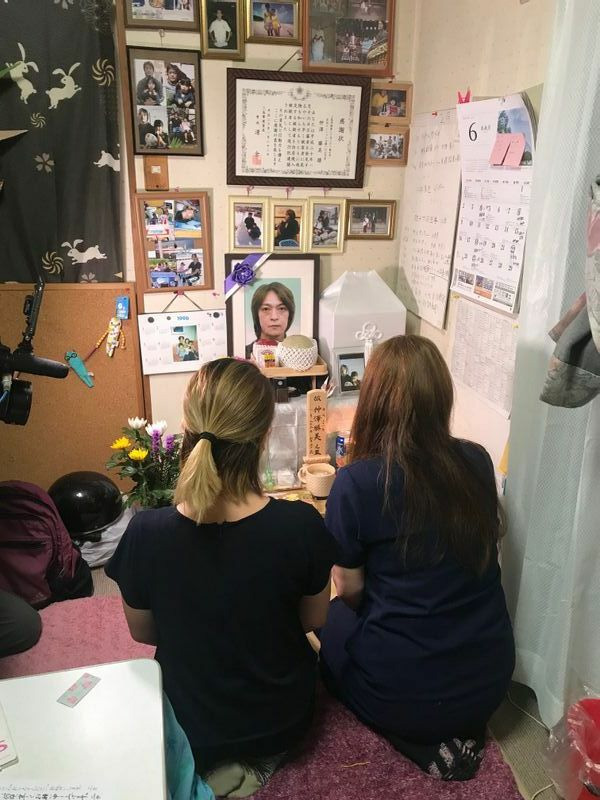 2年前の事故で亡くなった仲澤勝美さんの遺影に語り掛ける妻と長女（筆者撮影）