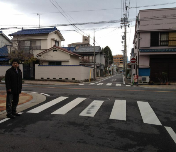 名古屋市内の事故現場に立つ、被害者の父親・眞野さん。加害者はこの横断歩道で大学生の貴仁さんを猛スピードではね、そのまま逃走した（筆者撮影）