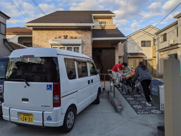 車椅子を押しながらスロープを上って介護用に建てた住宅に入る（筆者撮影）