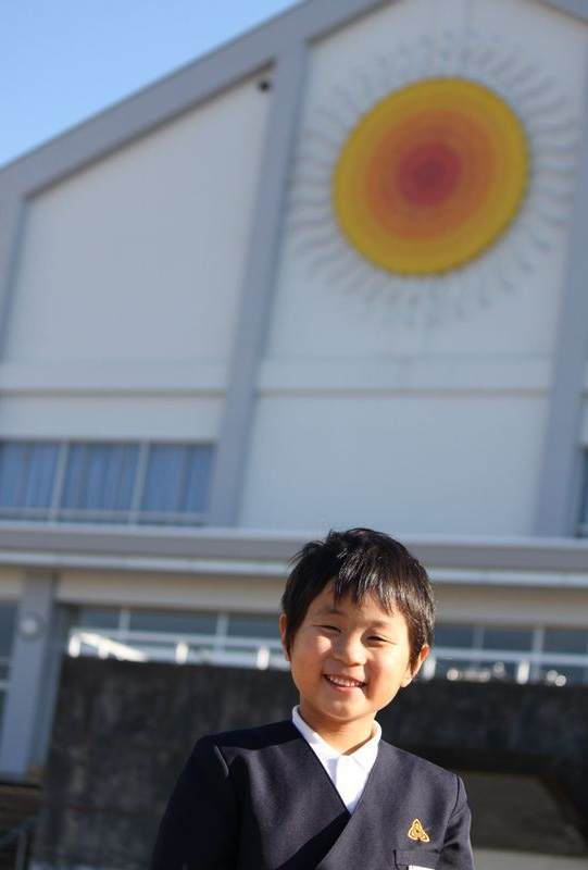 １年生の学習発表会の後、小学校のグラウンドで。後ろの太陽マークはこの小学校の象徴。この日の心誠くんはとてもご機嫌だったという（遺族提供）