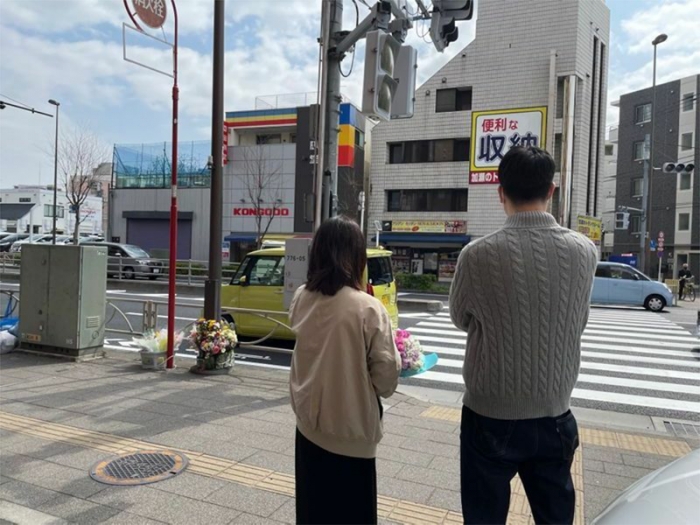 耀子さんが亡くなった横断歩道を見つめる波多野さん夫妻（筆者撮影）