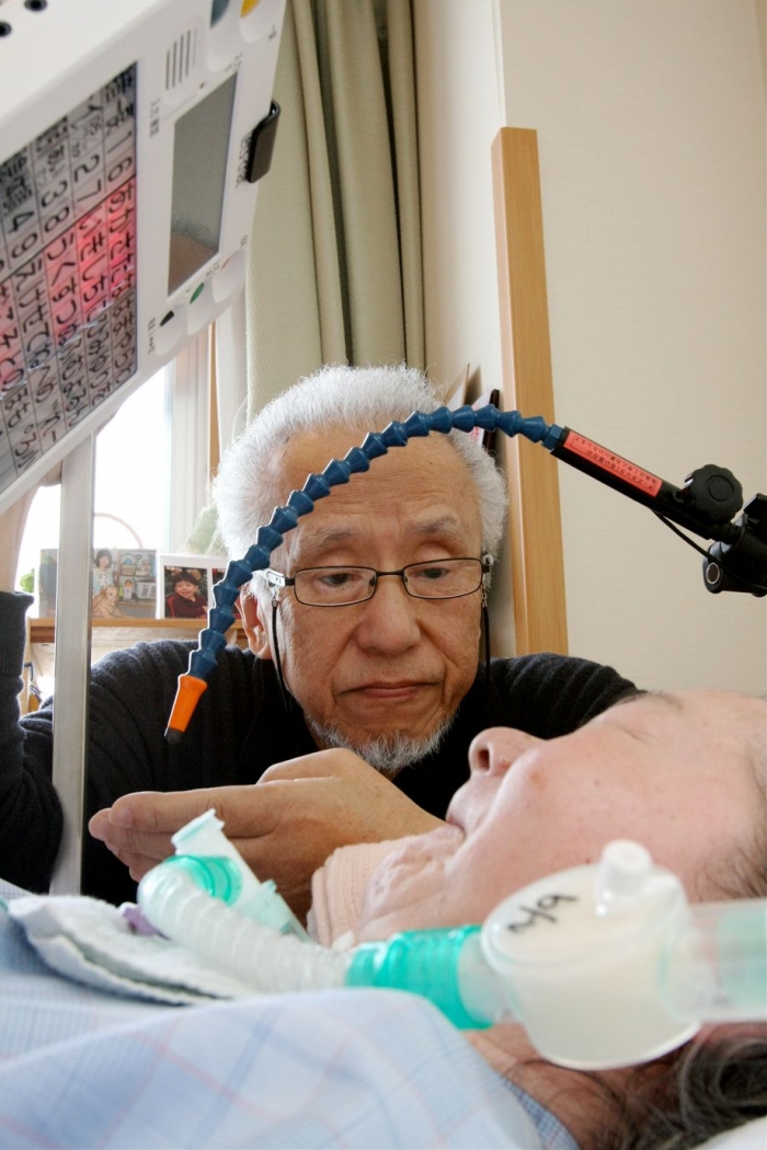 病室で妻・巻子さんを見つめる松尾さん