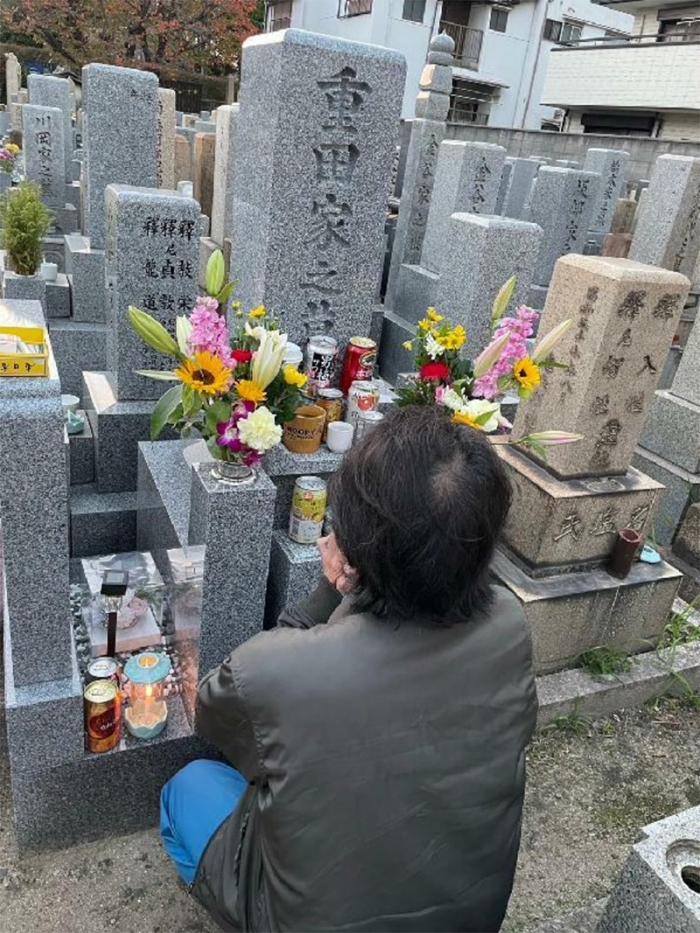 玲菜さんの墓前で手を合わせる父の直樹さん（遺族提供）