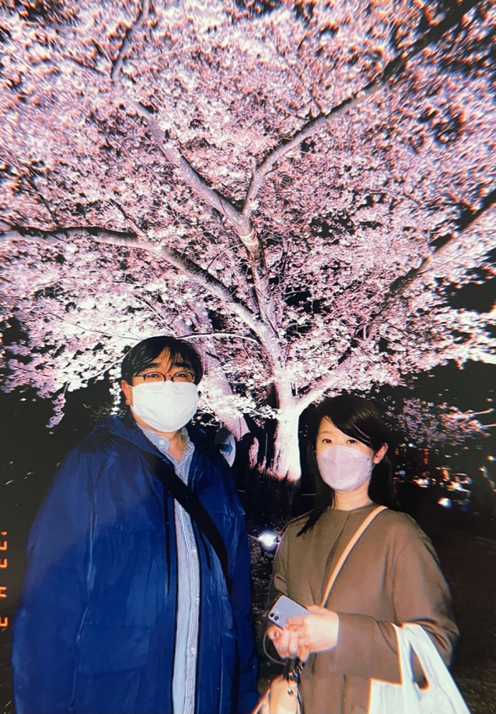 学生時代に知り合い、ずっと一緒だったという文明さんと妻の和技さん。最後となった夜桜をバックに（遺族提供）
