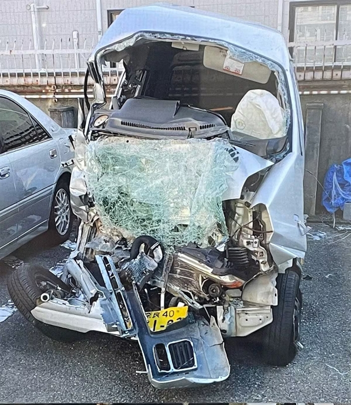 面衝突の衝撃を受け、前部が大破した被害車両