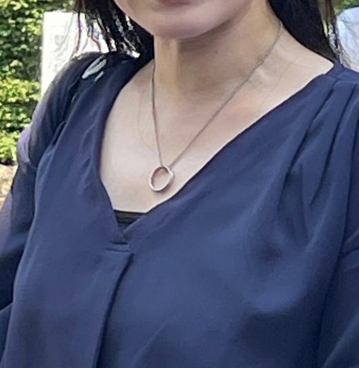 杉平智里さんの胸には、ネックレスとなった亡き夫の形見の結婚指輪が(筆者撮影)