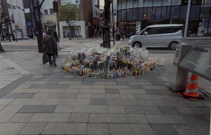 発生直後、献花が絶えなかったという現場。警察から遺品と一緒に送られてきた写真は、丁寧にラミネート加工が施されていたという（遺族提供）