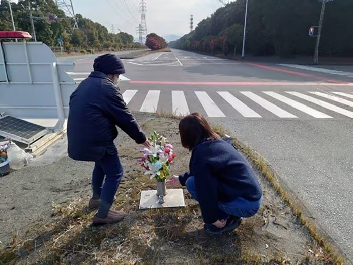 現場で献花する遺族