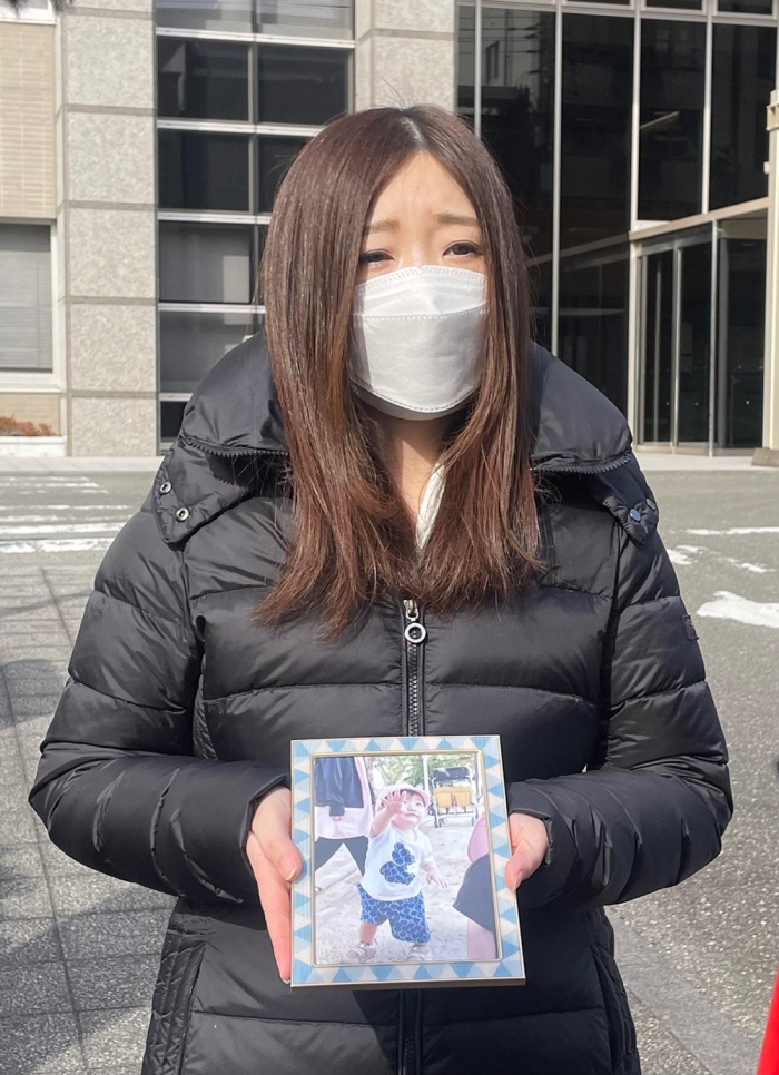 裁判を負え、高知地裁の前で煌瑛ちゃんの遺影を手にする母の彩乃さん（筆者撮影）